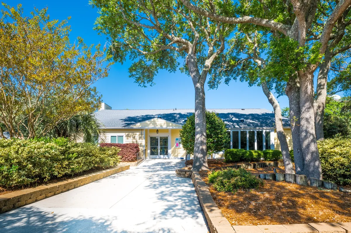 This exterior shot shows the building’s front entrance framed by tall, leafy trees and a well-maintained pathway. The peaceful outdoor atmosphere suggests opportunities for gathering, relaxing under the trees, or setting out on a day of exploration. It embodies the 'launchpad' idea for starting nature-based adventures.